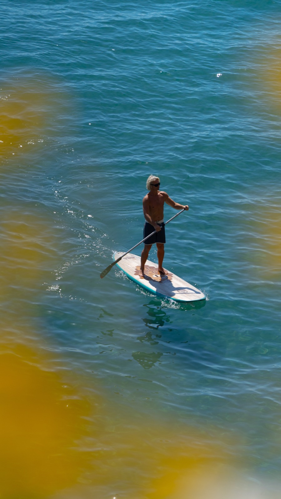A guest paddling the Agave 10 across clear turquoise water